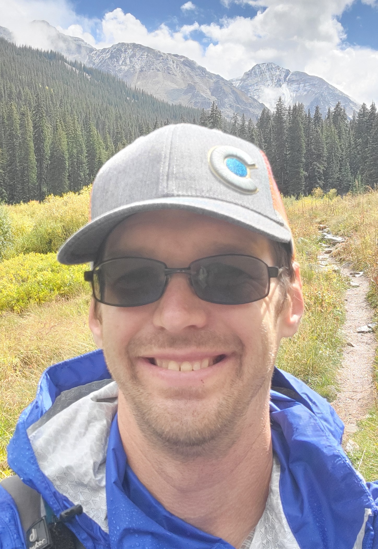 a photo of matt o'malley, a fired USDA agricultural engineer, smiling in front of mountains