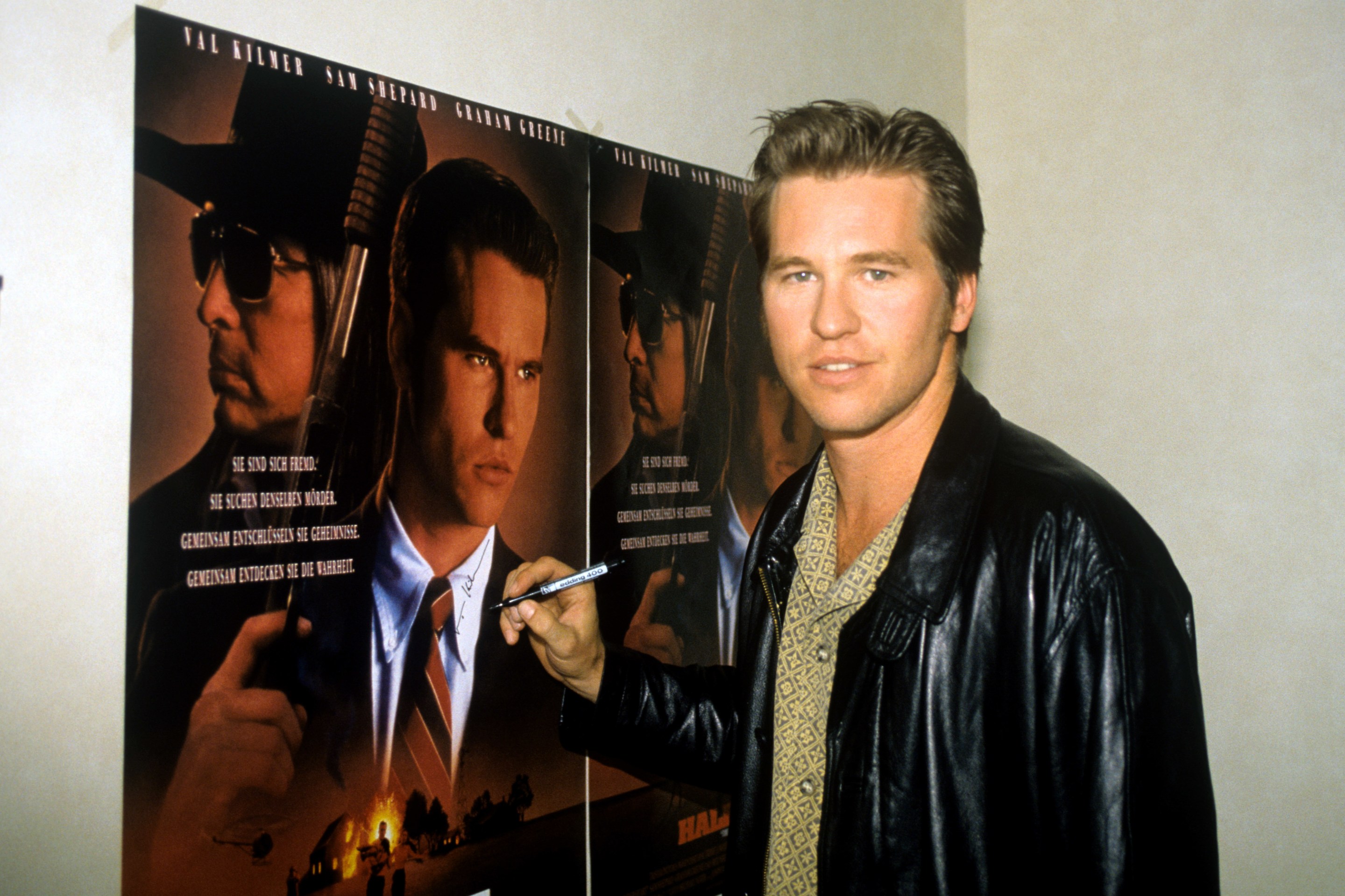 Photo of Val Kilmer signing a movie poster.