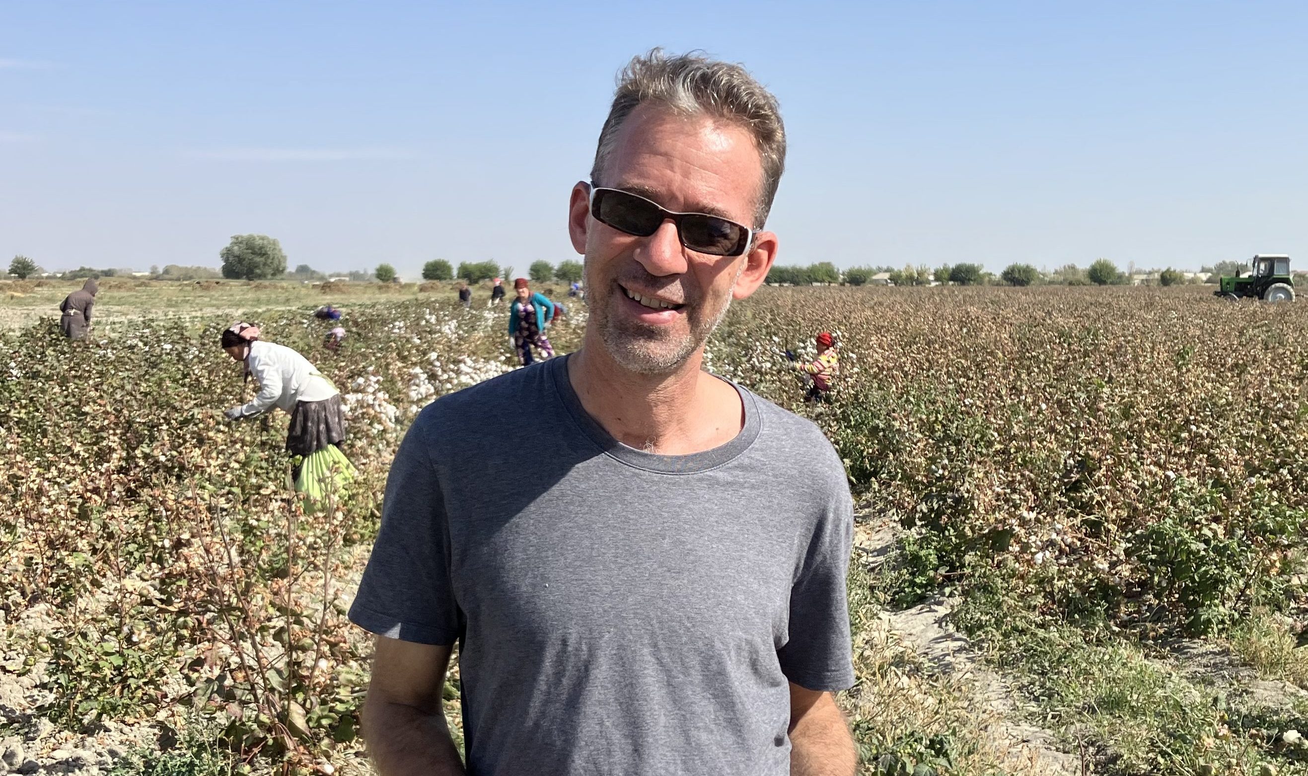 A photo of a USAID education officer, Joel Runnels, standing in a field