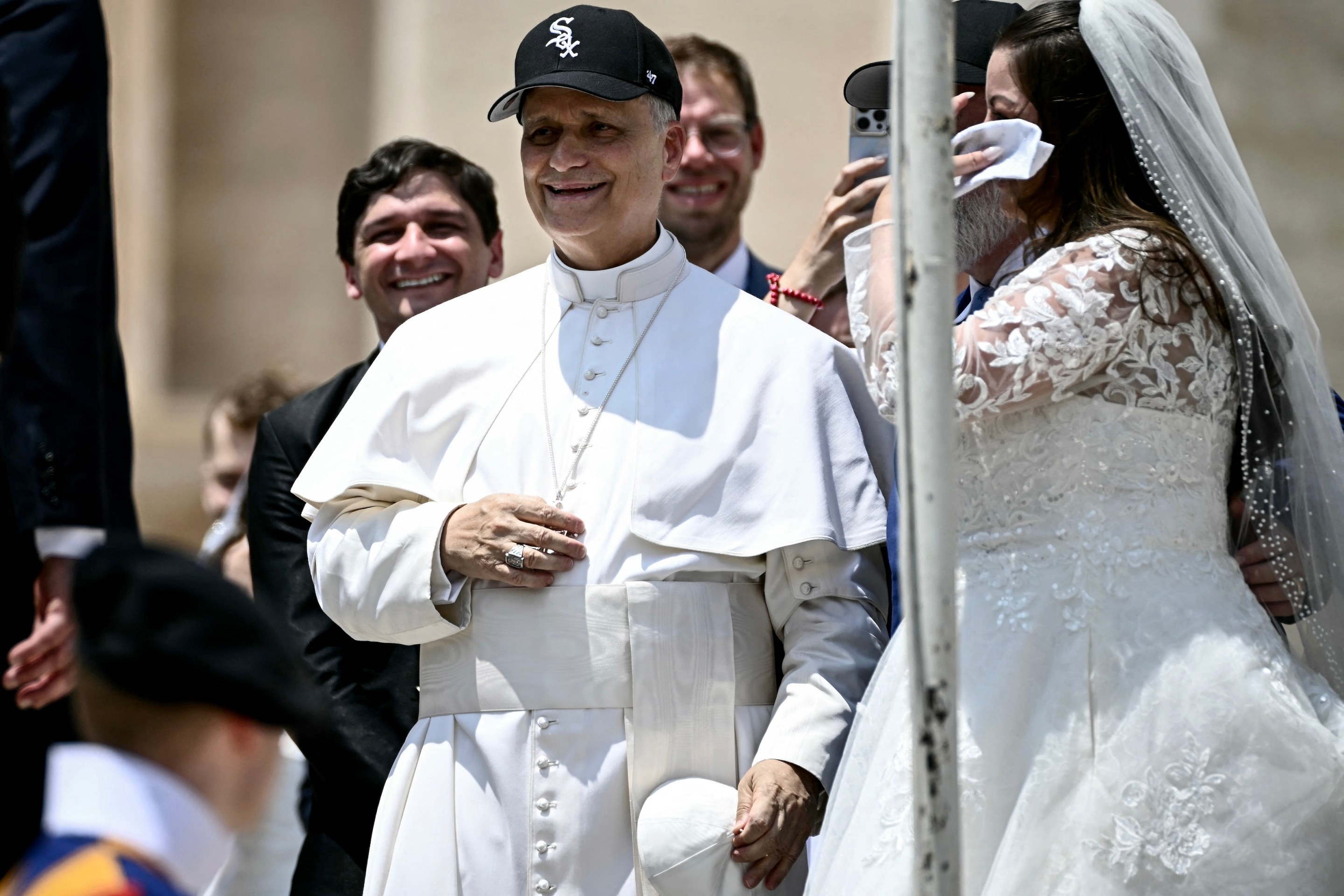 Pope Leo XIV (C) reacts wearing a Chicago White Sox baseball team cap as he meets newly wedded couples during the weekly general audience in St Peter's Square at the Vatican on June 11, 2025. (Photo by Filippo MONTEFORTE / AFP)